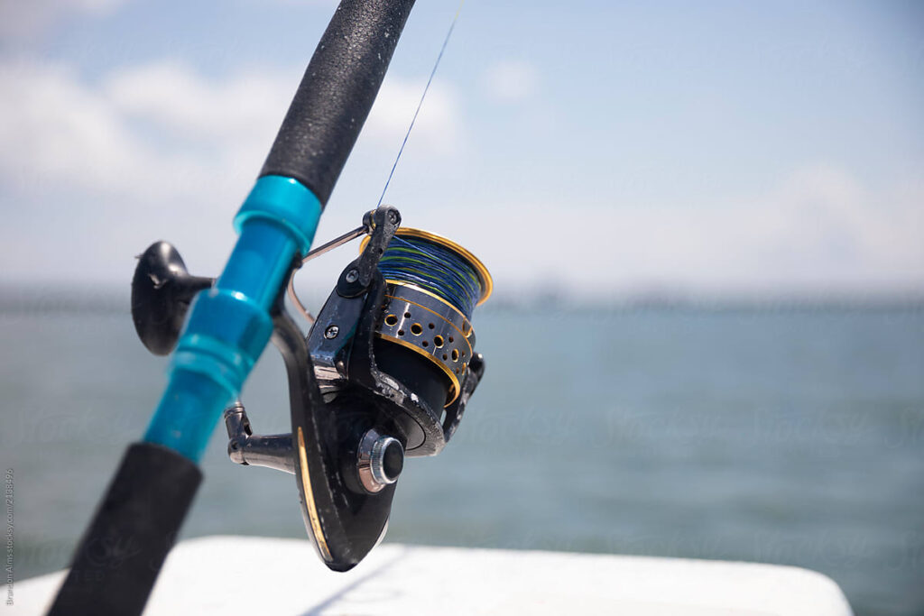 Angler using a best spincast reel while standing by a river for fly fishing