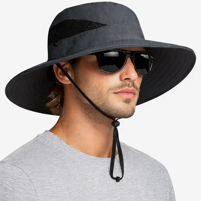 Charcoal wide-brim outdoor fish hat with mesh ventilation panel worn by a male model, lifestyle studio image.