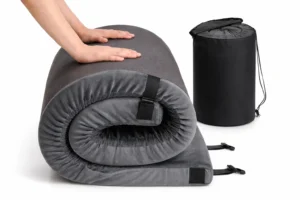 a roll-up best camping mattress
topper being compressed by two human hands